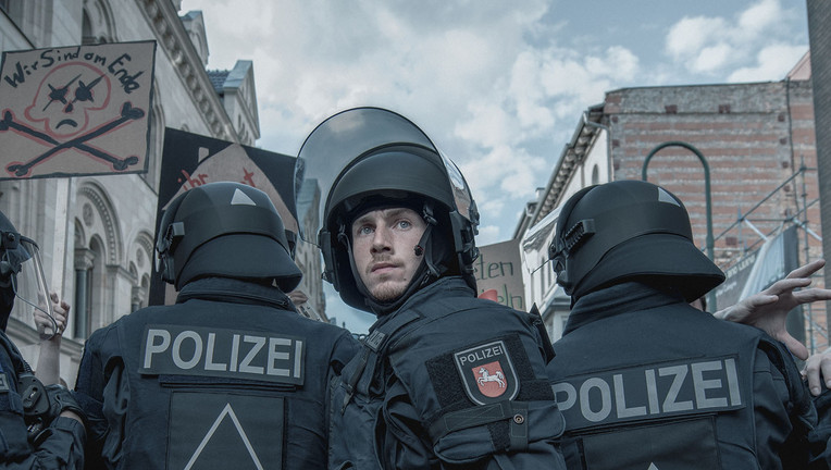 Eine vom Demonstrationszug abgetrennte Splittergruppe taucht vor dem gefährlichen Engpass einer Baustelle auf. Der Einsatztrupp der Polizei um Gruppenführer Jan Vogt (Justus Johanssen, M.) versucht, die Demonstrierenden zurückzudrängen.
ZDF/Adrian Gross