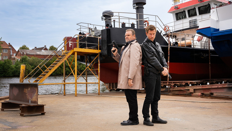 Kommissar Brockhorst (Felix Vörtler, l.) und Henk Cassens (Maxim Mehmet, r.) ermitteln im Fall eines havarierten Frachtschiffs.
ZDF/Michael Kötschau