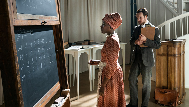 BU: Alexander Hoffmann (Leonard Scheicher), ein ehrgeiziger Ethnologie-Doktorand, lernt Kezia Kambazembi (Girley Charlene Jazama) kennen, als diese mit einer Delegation von Herero und Nama aus der Kolonie „Deutsch-Südwestafrika“ als Dolmetscherin nach Berlin reist.

Copyright: ZDF/Julia Terjung